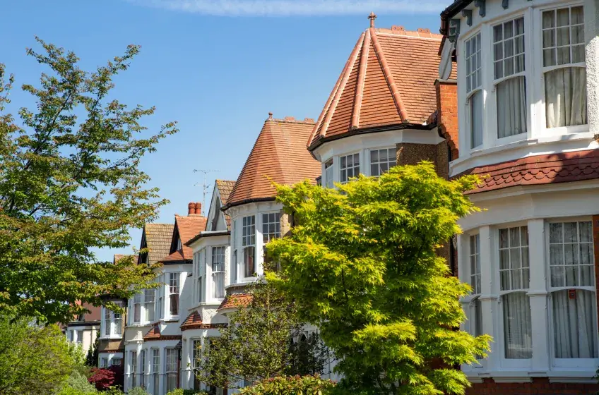 A row of bay-fronted period houses on a sunny North London street